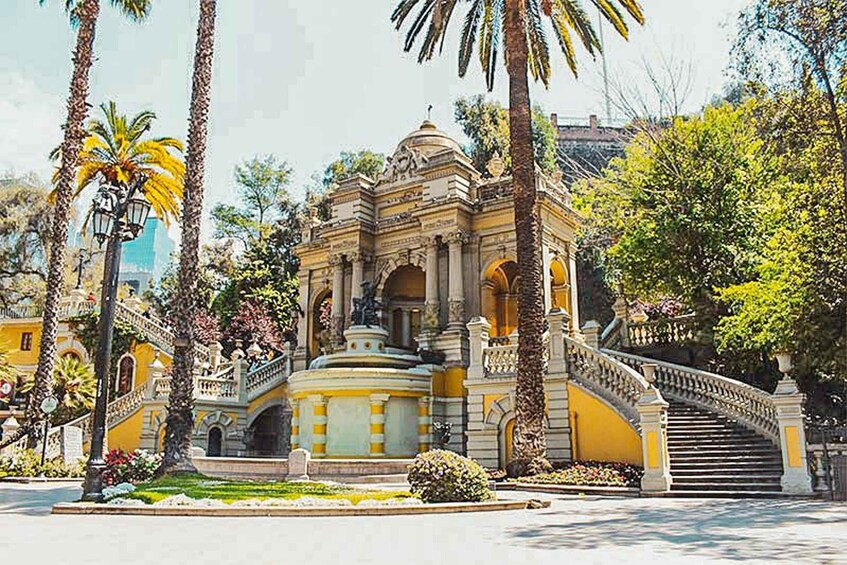 A historic building with ornate architecture, a staircase, and palm trees. 3
