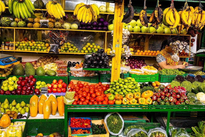 A vibrant market stall with various fruits and vegetables, including bananas, apples, and tomatoes. 5