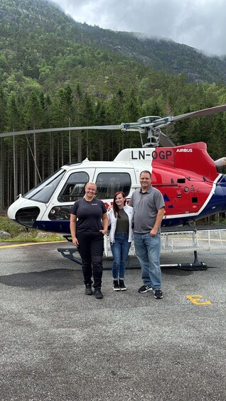 A helicopter with the registration LN-OGP parked on a helipad with a mountainous background. 5