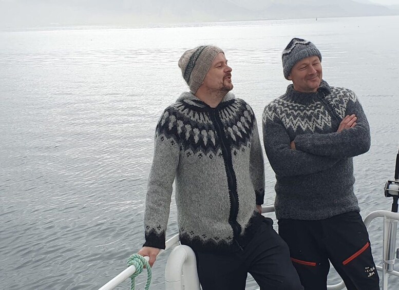 Two people on a boat wearing winter clothing. 3