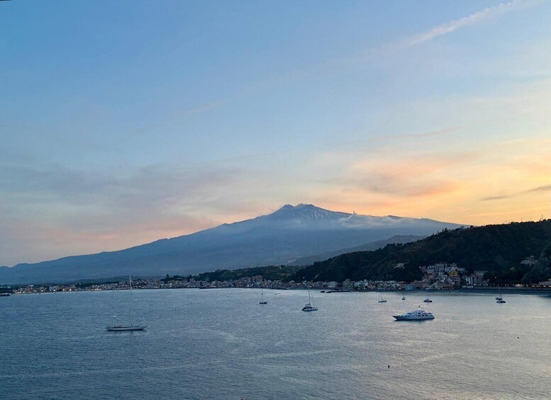 A coastal town with boats on the water and a mountain in the background. 5