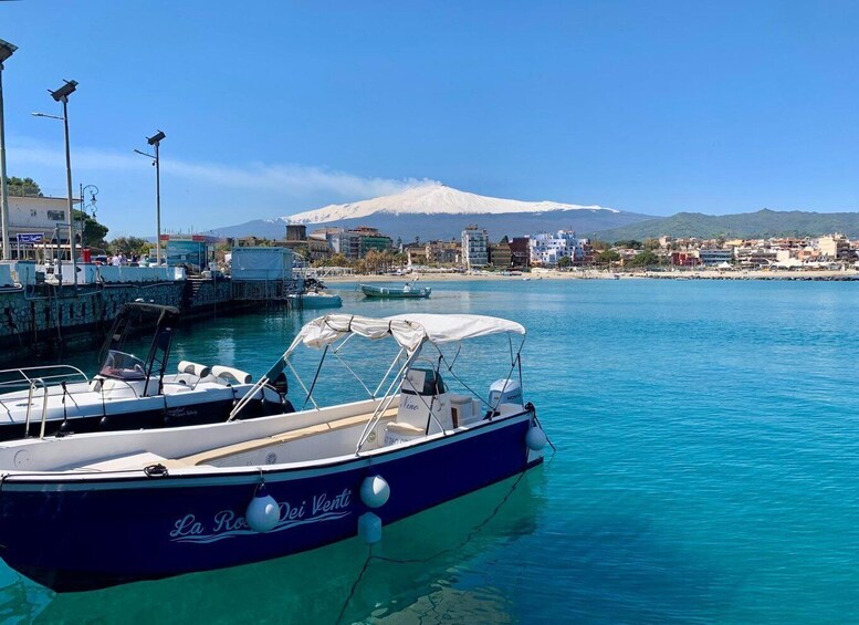 A marina with boats, a clear blue sky, and a mountain in the background. 2