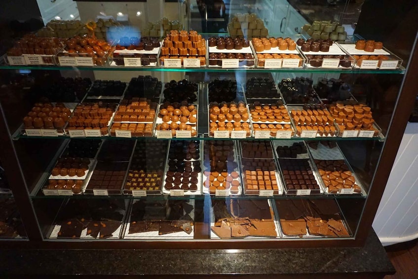 Ett vitrinskåp fyllt med olika sorters choklad. 5