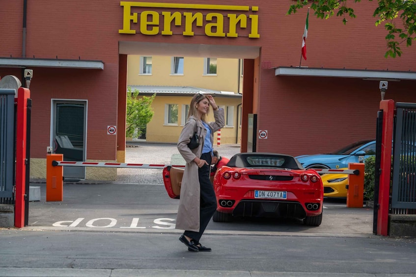 En person går förbi en Ferrari-återförsäljare där en röd sportbil står parkerad utanför. 1