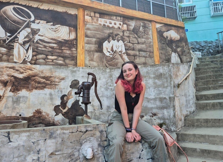 A mural with historical figures and a vintage water pump. 4