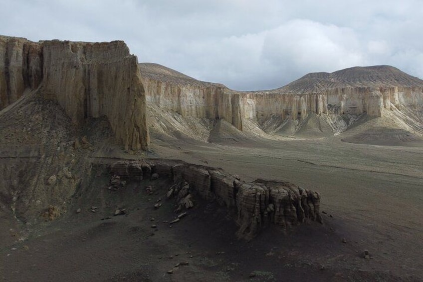 A barren landscape with steep cliffs and a flat valley. 5