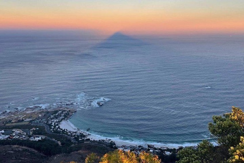 A coastal landscape with a beach, ocean, and a distant mountain. 2