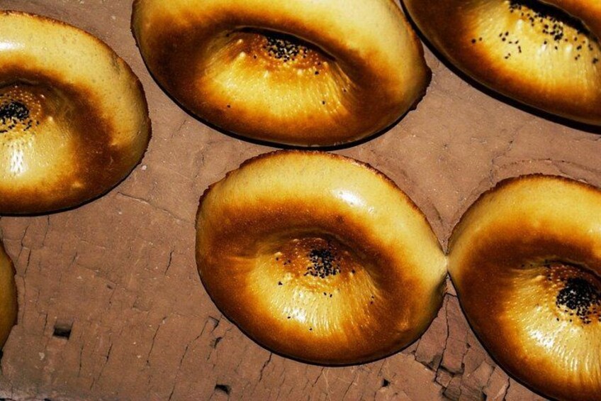 A close-up of several bagels with sesame seeds on a wooden surface. 2