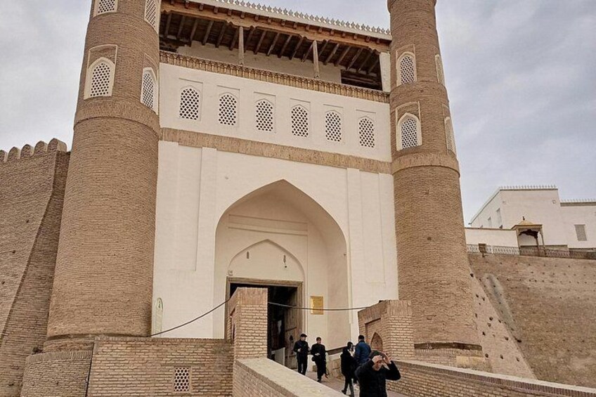 A historic gate with arched entryway, two tall towers, and a brick wall. 5
