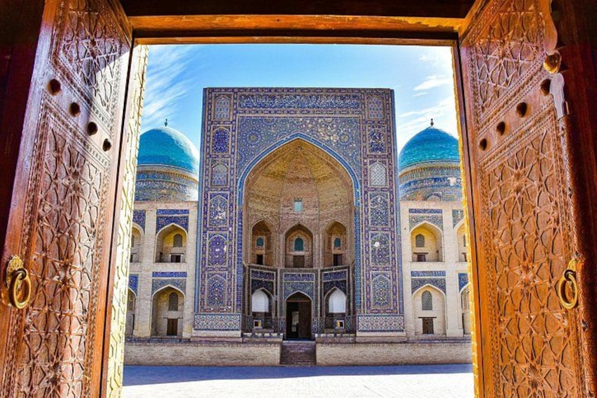 A grand entrance with intricate tile work and domed structures. 1