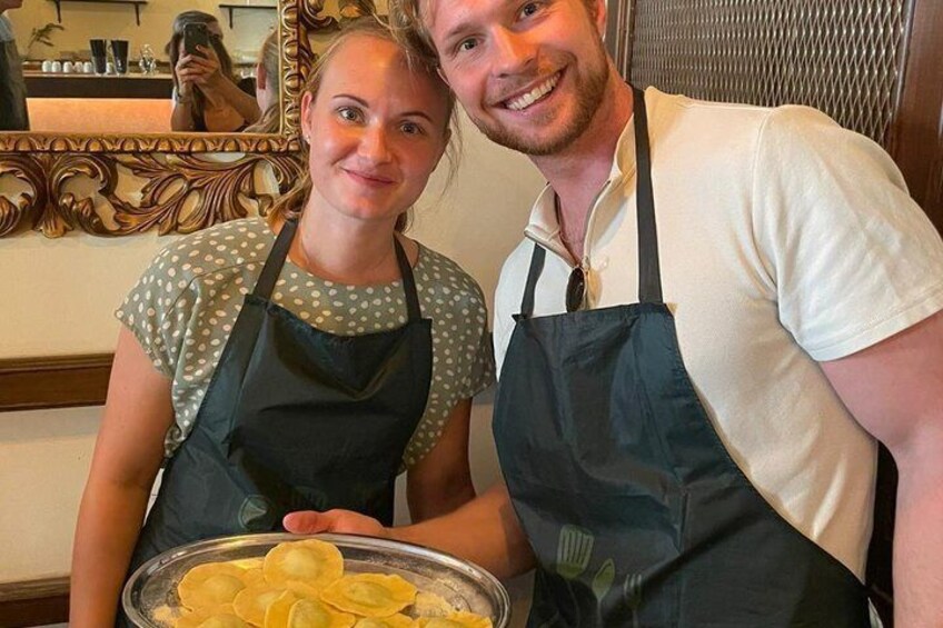 Två personer med förkläden på sig, varav en håller i en skål med chips. 1