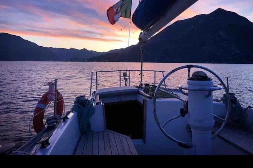 A boat on calm water with a mountainous landscape in the background. 1