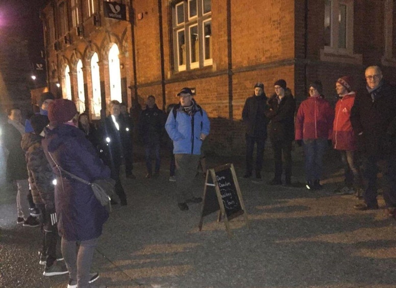 A group of people standing in front of a building at night. 3