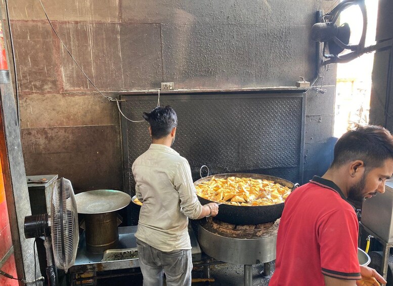 A cooking area with a large pot and a fan. 3