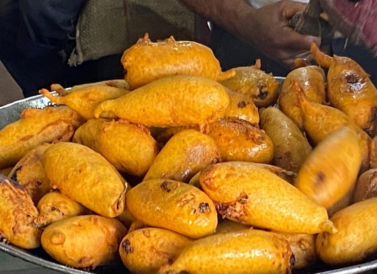 A large tray of golden-brown fried doughnuts. 2
