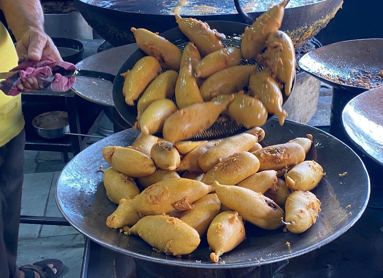 A person cooking food in a large wok. 5