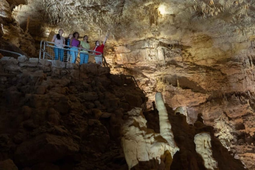 A group of people observing cave formations and stalactites. 5