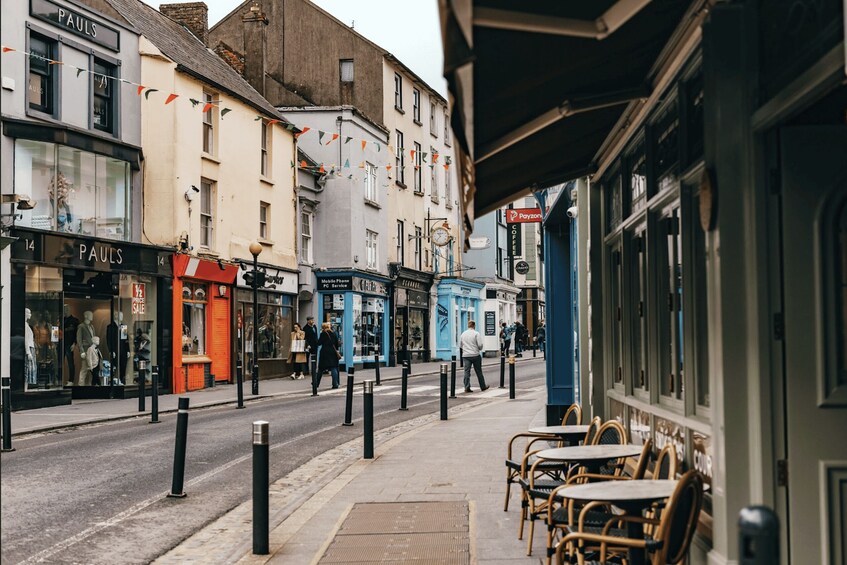 Une rue commerçante, avec notamment un magasin « PAULS » et des terrasses. 4
