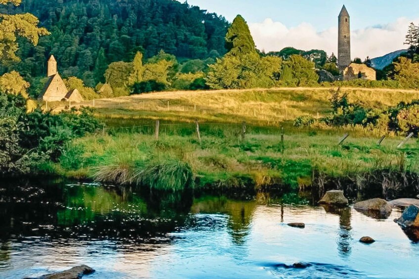 Une rivière bordée de rochers, une église et une tour au milieu d’un paysage verdoyant. 5