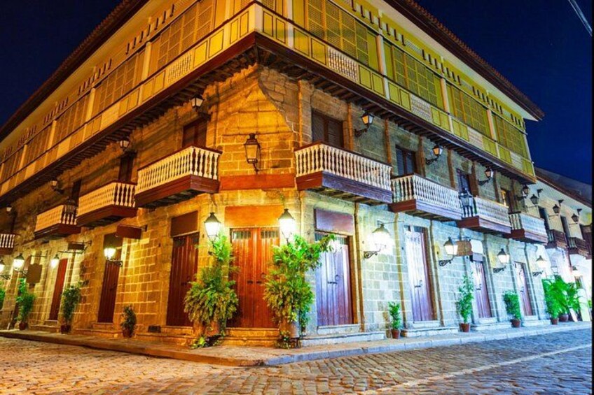 A historic building with multiple balconies and lit windows at night. 4