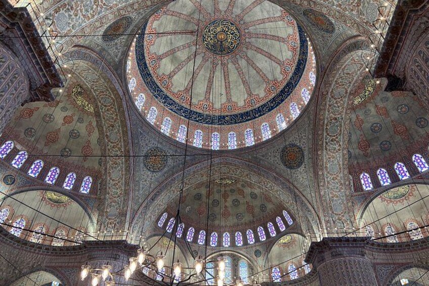 A domed ceiling with intricate patterns and stained glass windows. 5