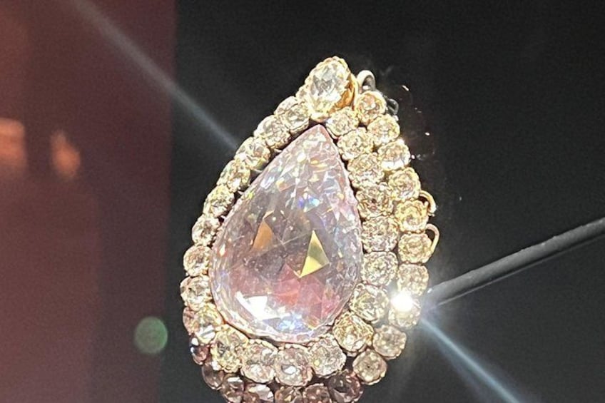 A close-up of a teardrop-shaped gemstone surrounded by smaller diamonds. 4