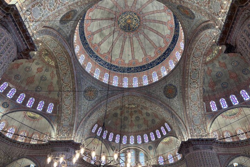 A domed ceiling with intricate patterns and stained glass windows. 5