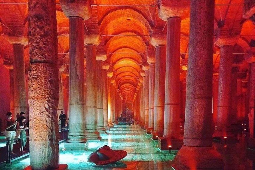 A long corridor with columns and a red-lit ceiling. 2