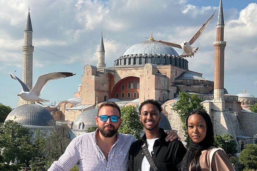 A group of people in front of a historic building with domes and minarets. 2