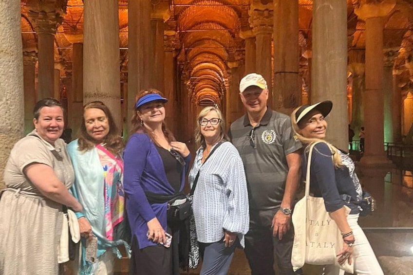 A group of people standing in a historical building with columns and arches. 5