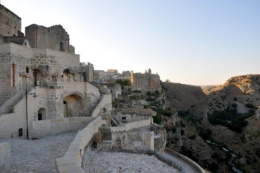 Un'antica città fortificata con edifici in pietra e un pendio ripido. 5