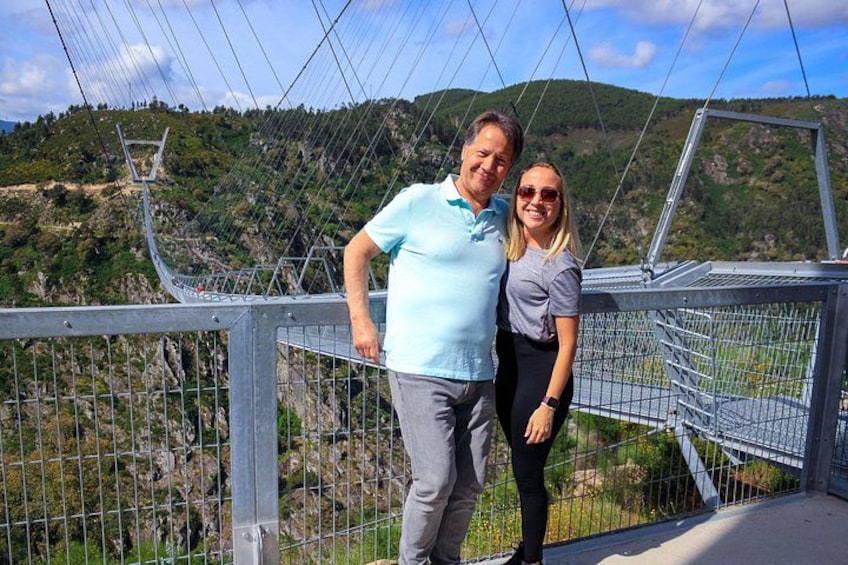 A suspension bridge with metal railings and a mountainous landscape in the background. 5