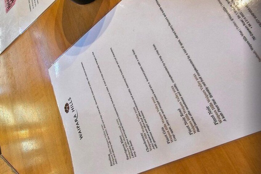 En meny med text och en logotyp på ett träbord. 3