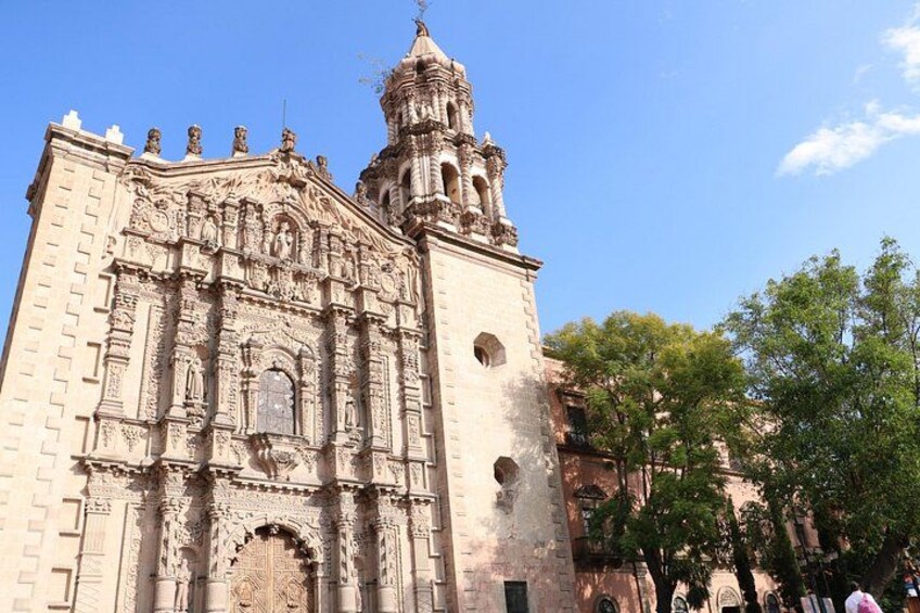 Una iglesia histórica con elaboradas esculturas en la fachada y un campanario. 4