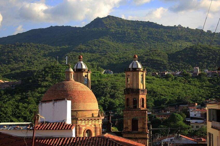 A church with a dome and bell tower, surrounded by a mountainous landscape. 4
