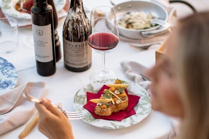 Una mesa de comedor con platos de comida, botellas de vino y copas. 1