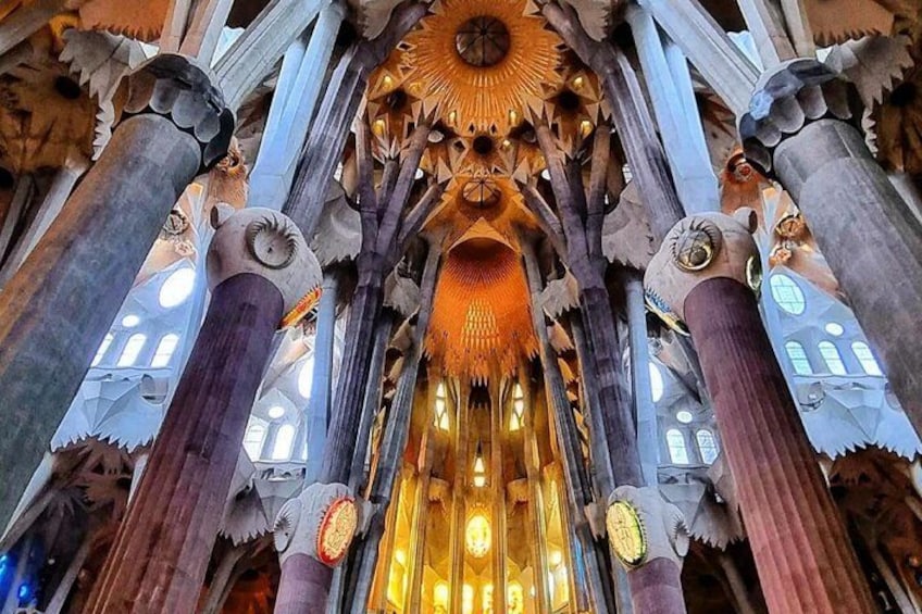 A detailed view of a building's interior with ornate columns, intricate ceiling designs, and a central illuminated area. 5