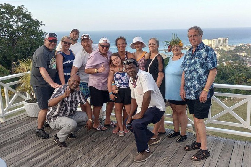 Un gruppo di persone su un pontile di legno con vista panoramica sull'oceano. 2