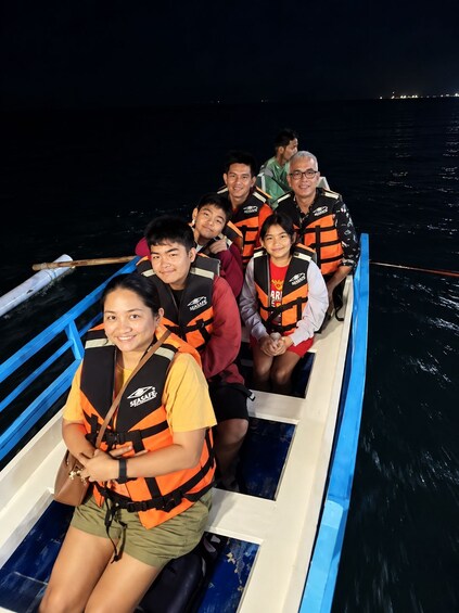 A group of people on a boat wearing life jackets. 3