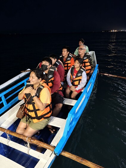 A group of people on a boat wearing life jackets. 4