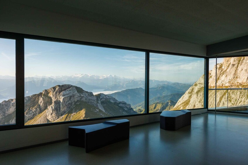 A room with large windows overlooking a mountainous landscape. 2