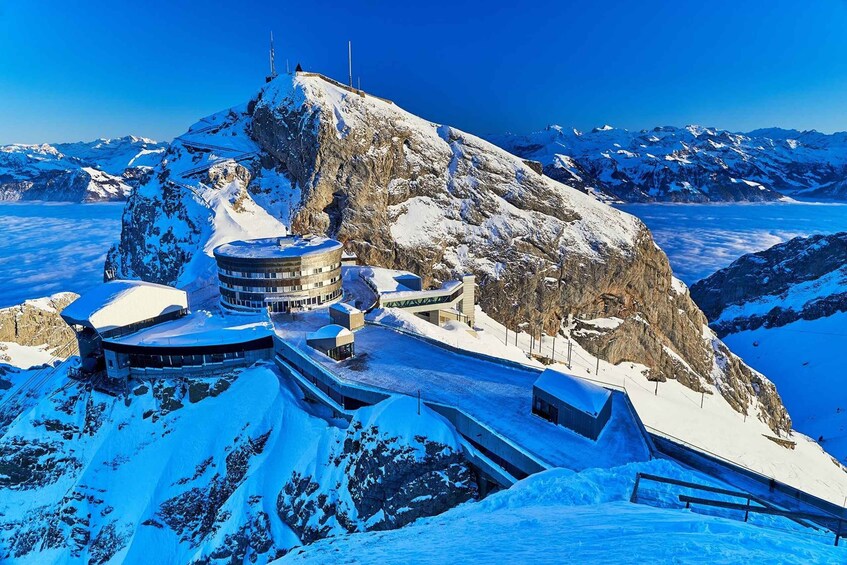 A snow-covered mountain with a ski resort, including buildings and ski lifts. 4