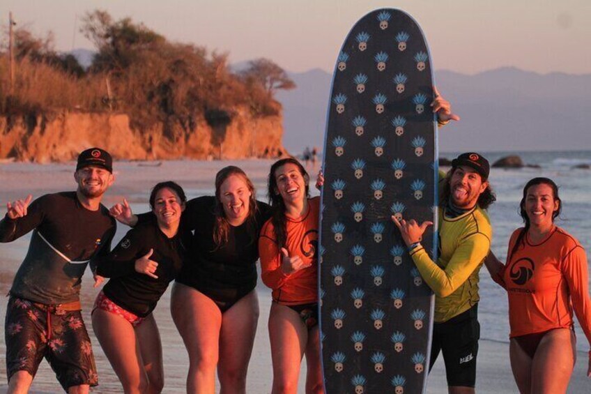A group of people on a beach with a surfboard. 3