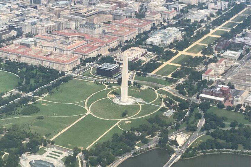 Vista aérea de una ciudad con un monumento destacado en el centro, rodeado de áreas verdes y un río. 5