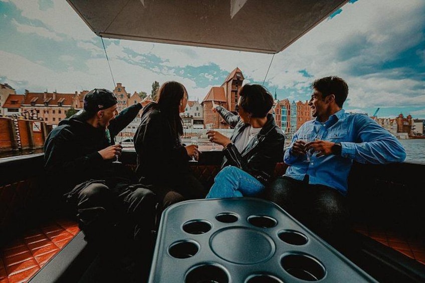 A group of people on a boat with a cityscape in the background. 3