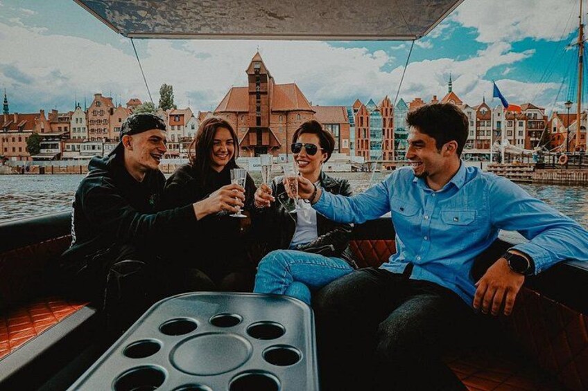 A group of people on a boat with a cityscape in the background. 1
