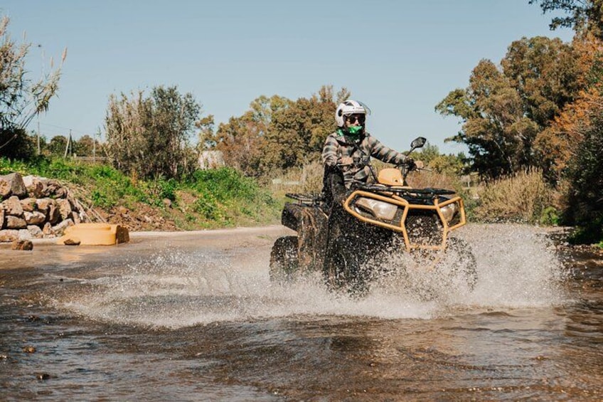 Une personne conduisant un véhicule tout-terrain dans une étendue d'eau peu profonde. 2