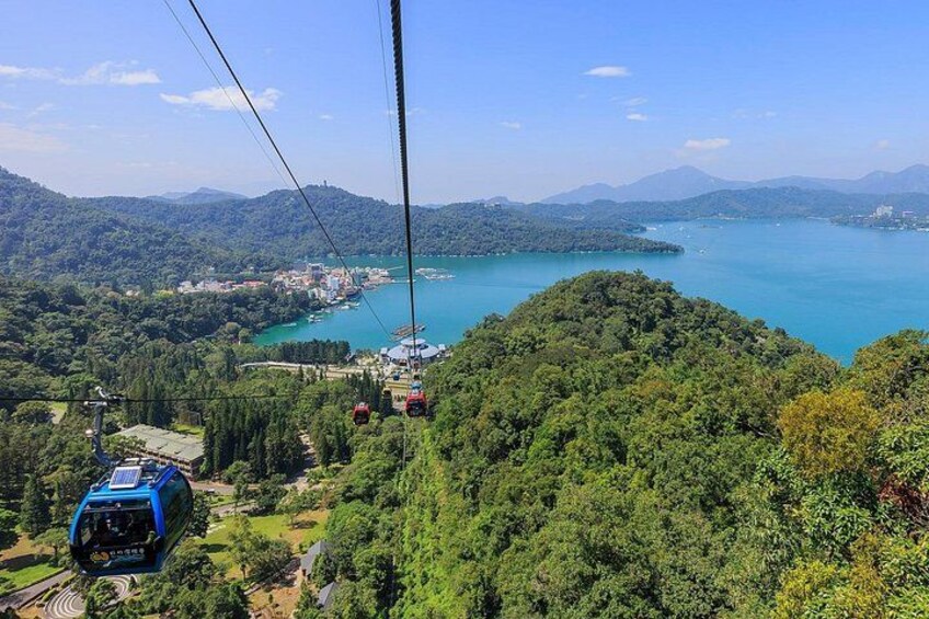 A cable car system, lush green hills, and a lake. 3