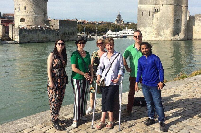 A group of people standing by a river with historical buildings in the background. 4