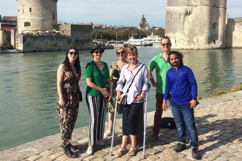 A group of people standing by a river with historic towers in the background. 4
